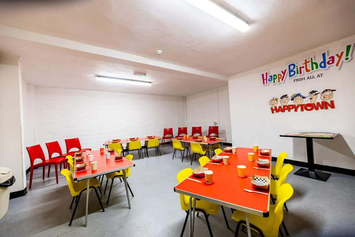 A Happy Town party room set with tables and chairs