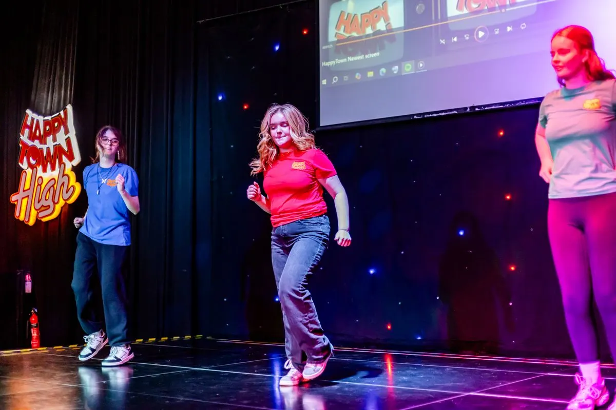 The Happy Town team dancing on stage